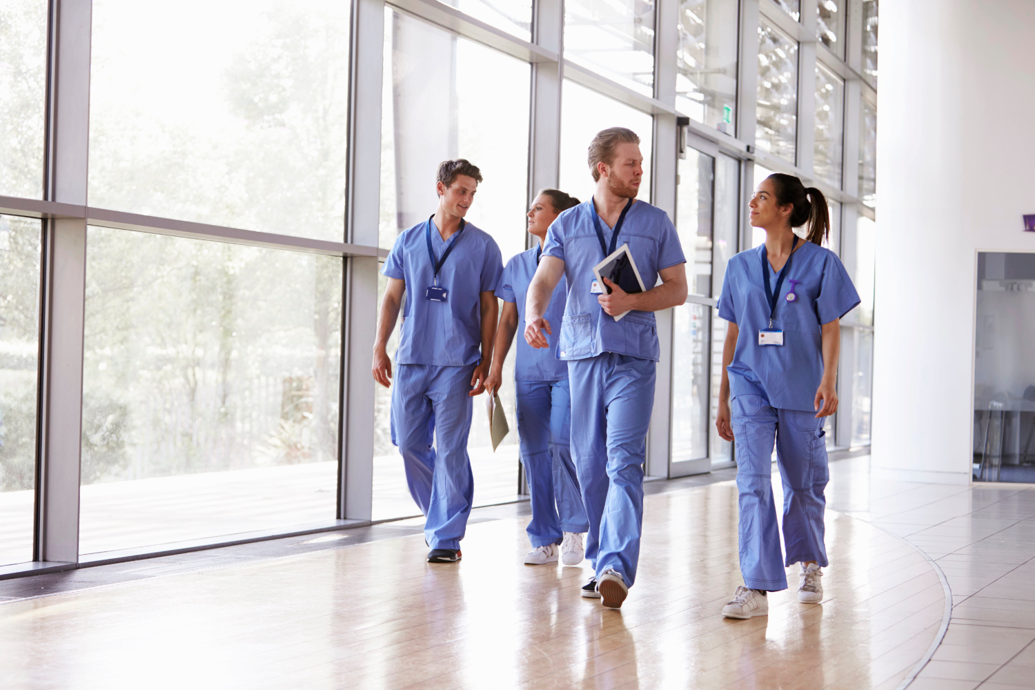 Group of people in scrubs walking